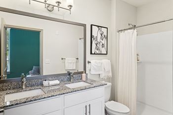 A bathroom with a toilet, sink, and shower.